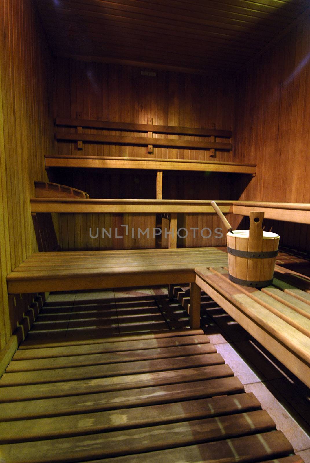 Empty wooden sauna with a bucket of water 