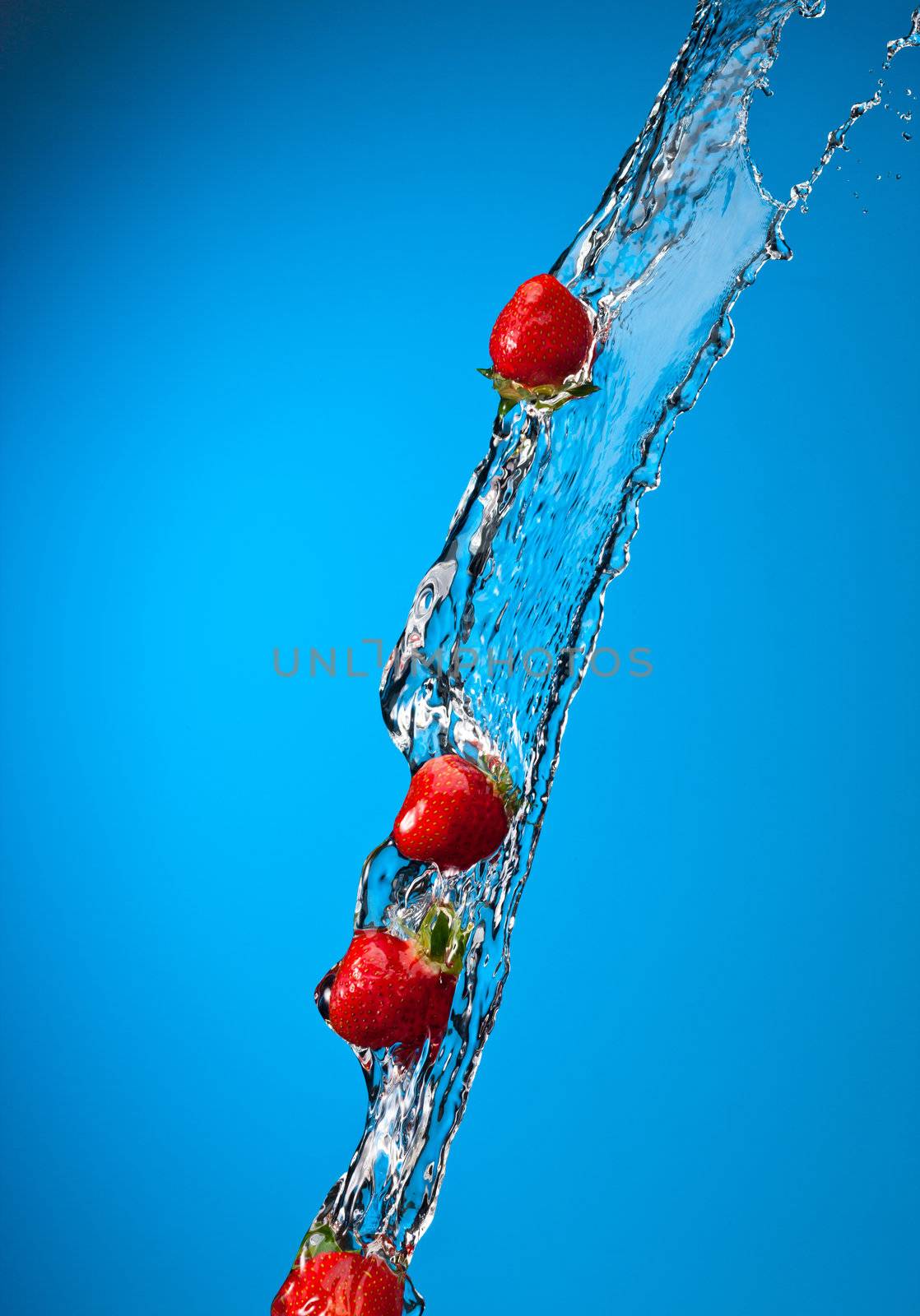 water splash with ripe red strawberry over blue background