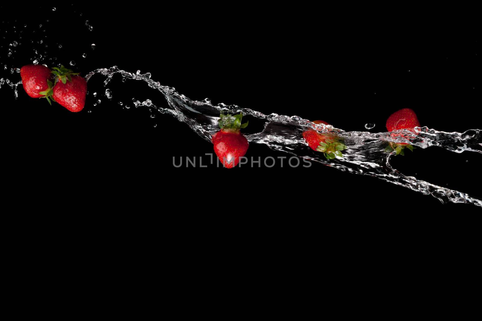 water splash with ripe red strawberry over black background