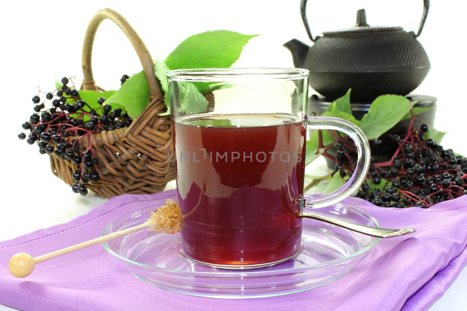 a glass of elderberry tea with fresh elderberries