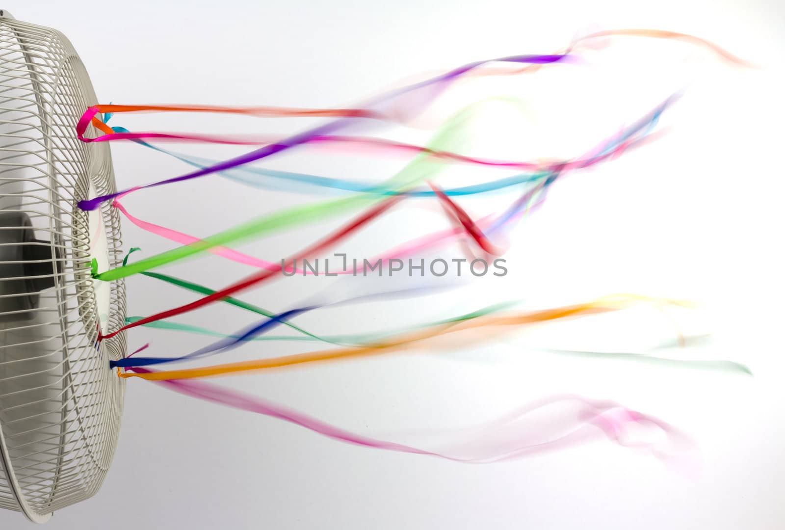 An electric fan blurring colorful silk ribbons