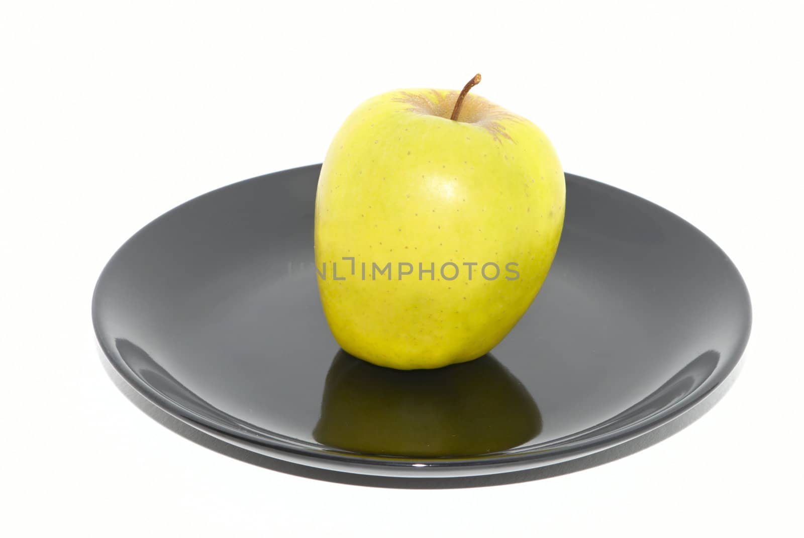 Green apple on the black plate