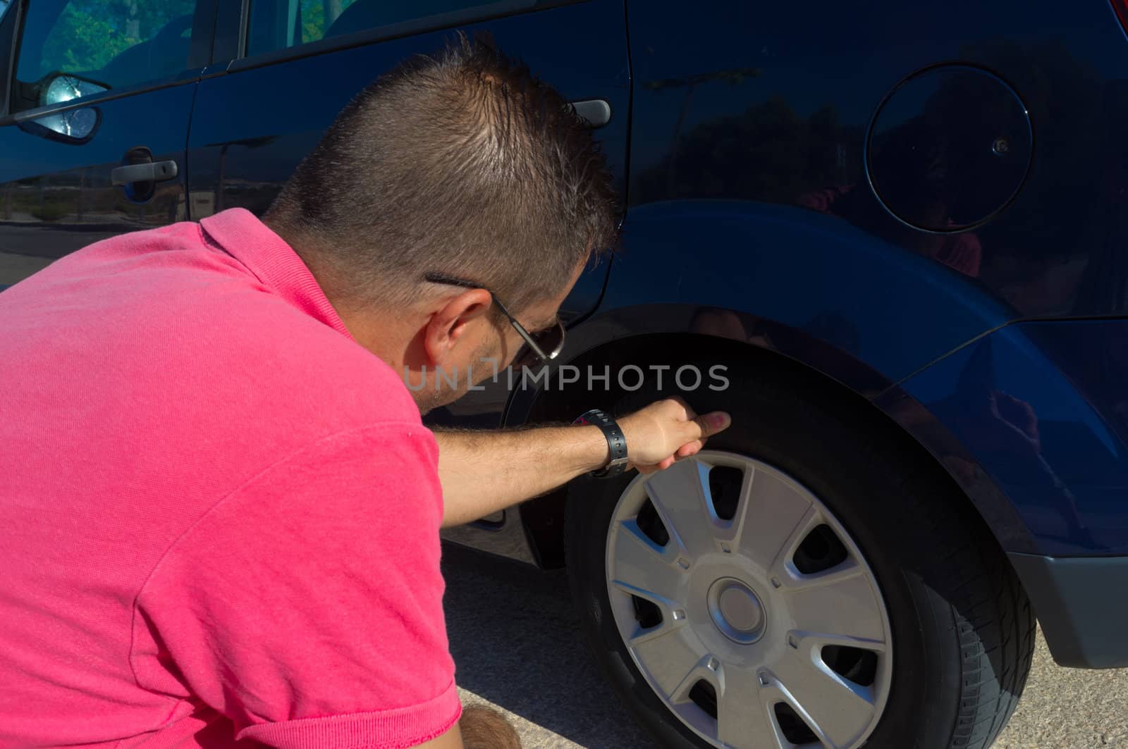 Male checking the general state of his tyres