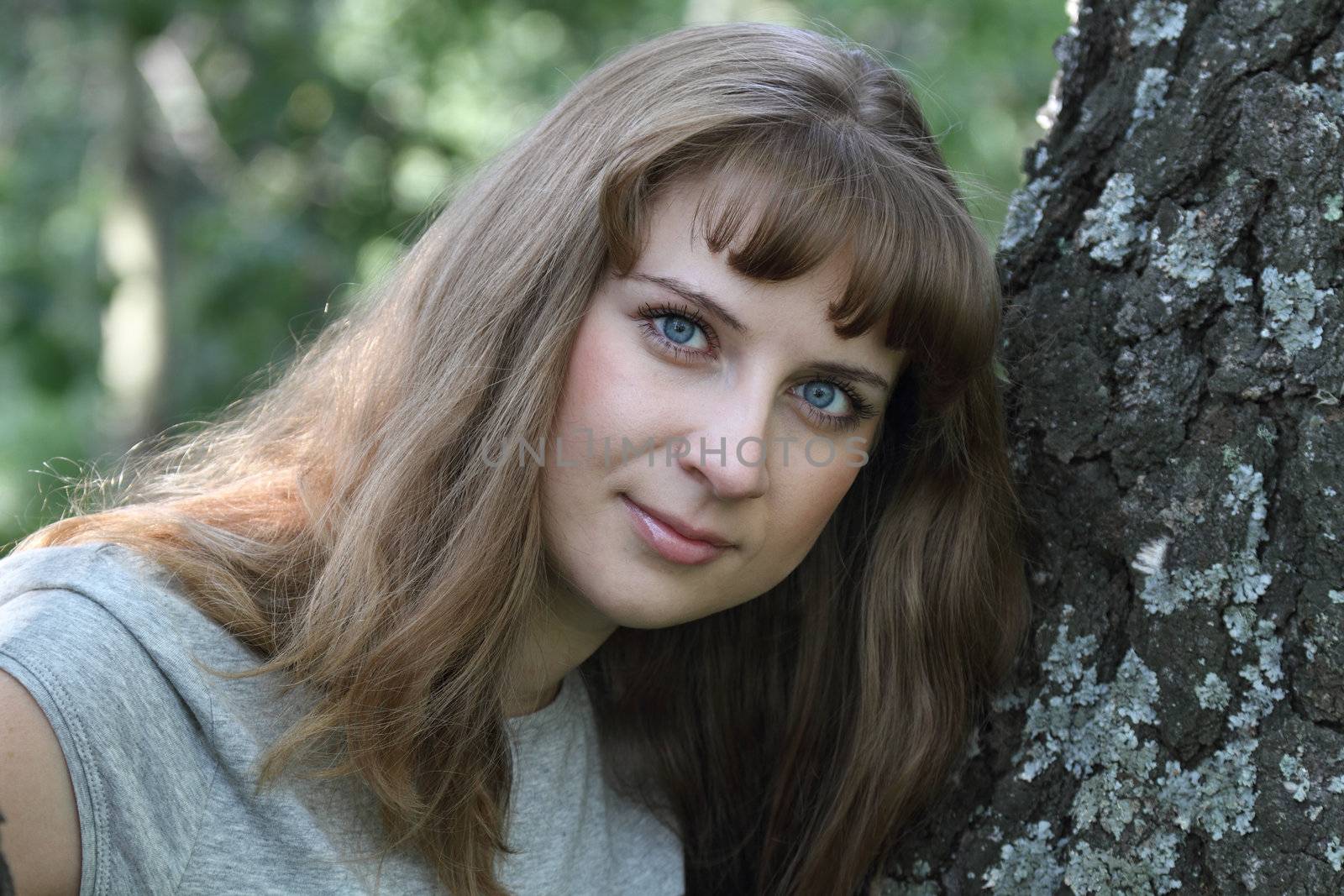 Portrait of the young girl about an old tree

