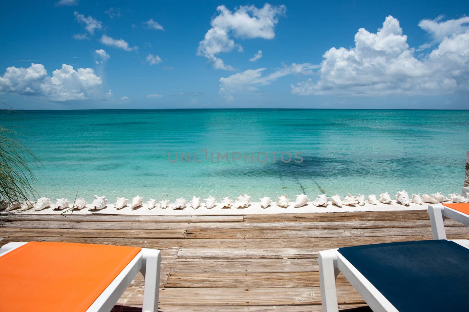 Loungers by the sea on deck at waters edge.