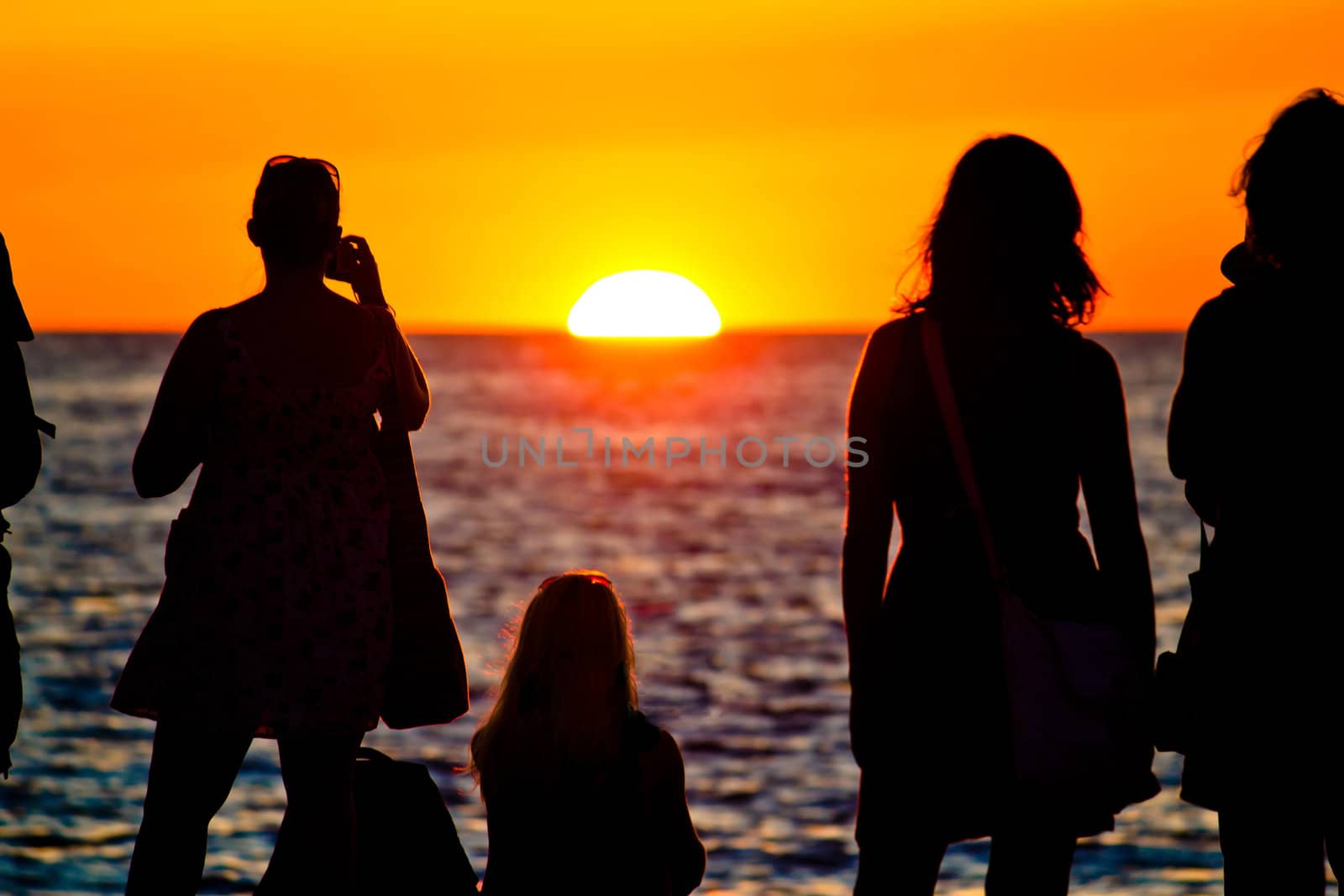 Women silhouette watching sunset on sea coast in Zadar, Dalmatia