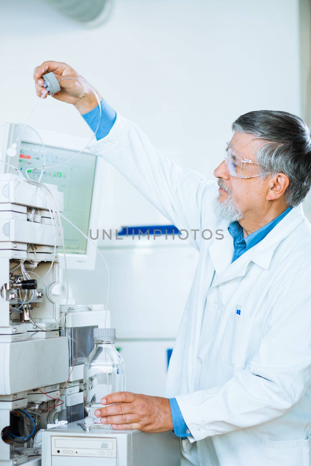 Senior male researcher carrying out scientific research in a lab (shallow DOF; color toned image)