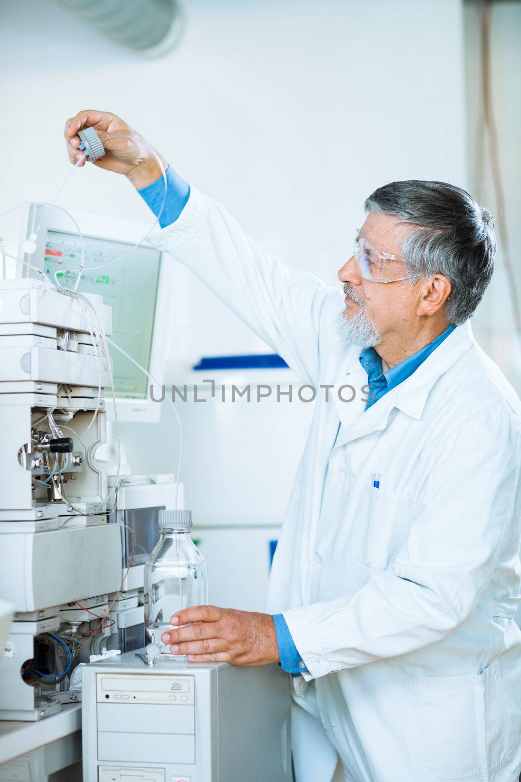 Senior male researcher carrying out scientific research in a lab (shallow DOF; color toned image)