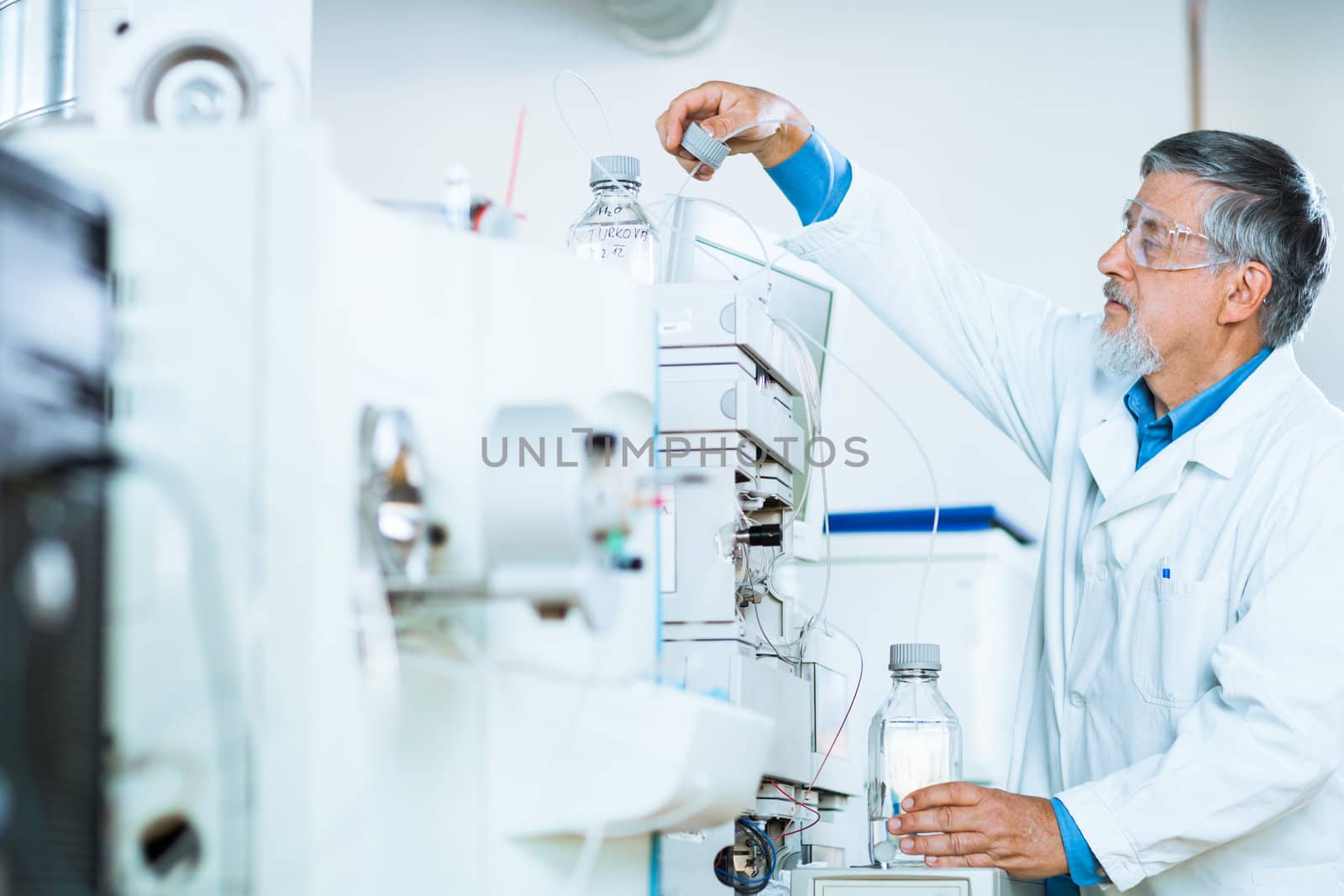 Senior male researcher carrying out scientific research in a lab (shallow DOF; color toned image)