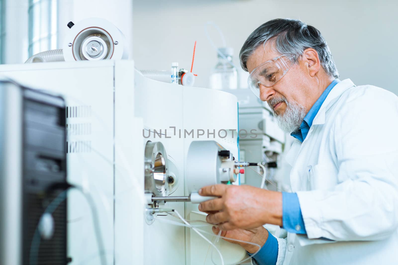 Senior male researcher carrying out scientific research in a lab (shallow DOF; color toned image)