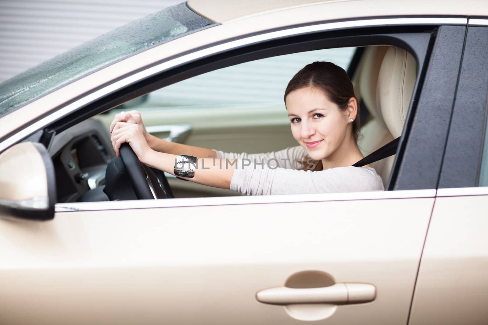 Pretty young woman driving her new car