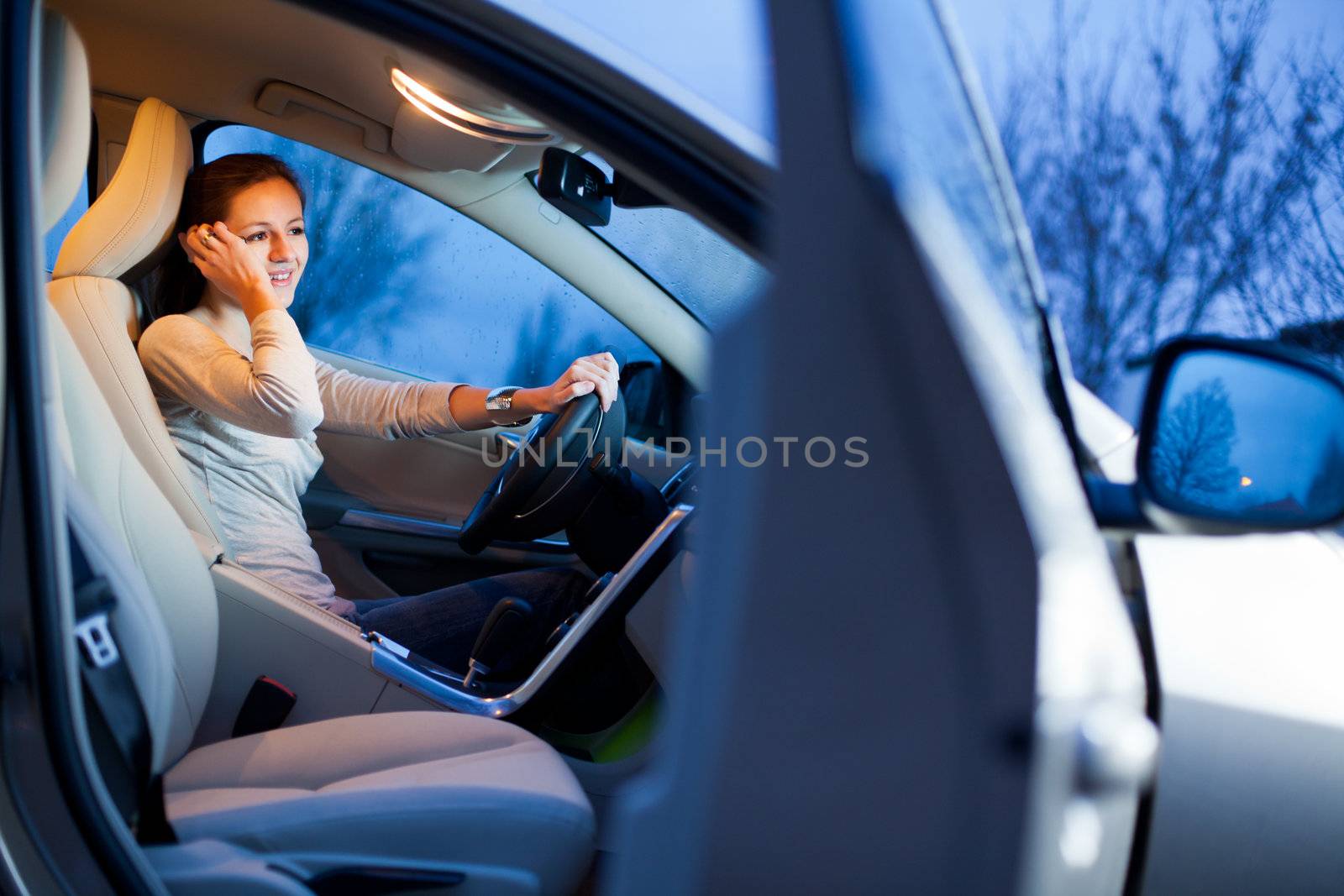 Pretty young woman driving her brand new car shallow DOF; color toned image)