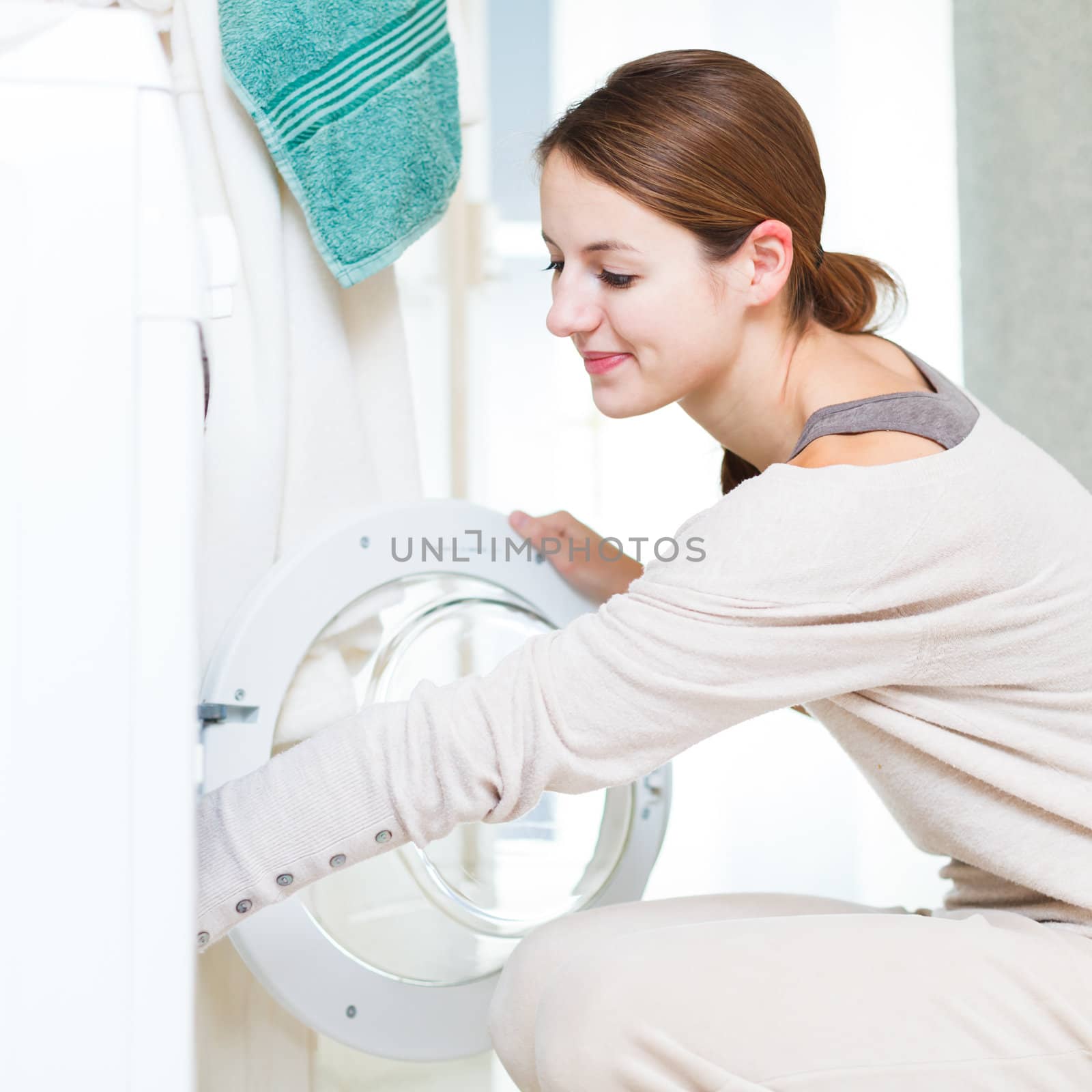 Housework: young woman doing laundry by viktor_cap
