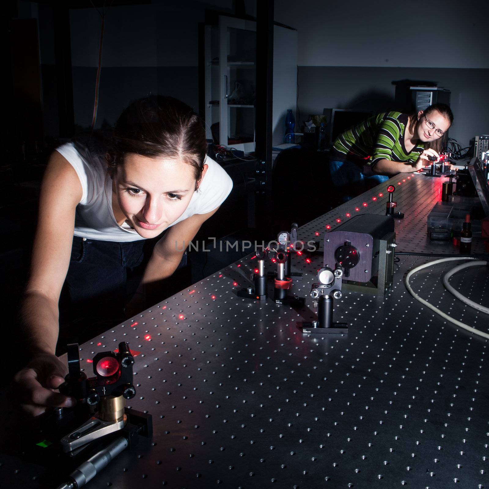 Female scientist doing research in a quantum optics lab  by viktor_cap