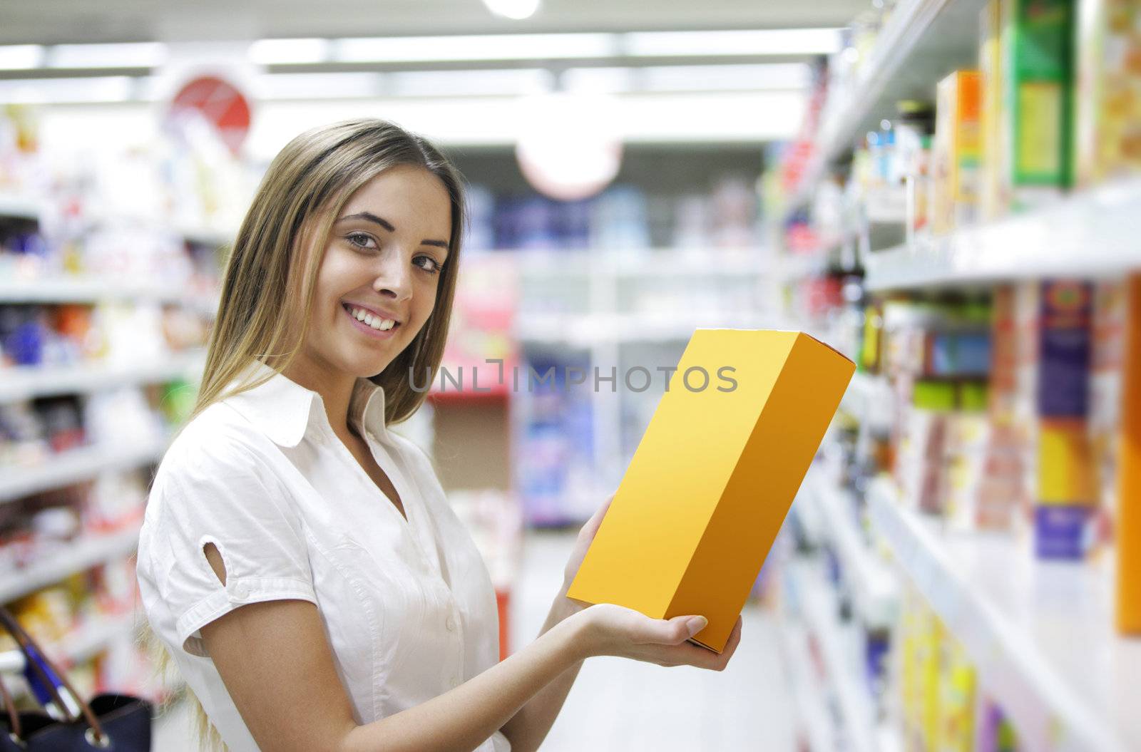 Woman checking food labelling in supermarket