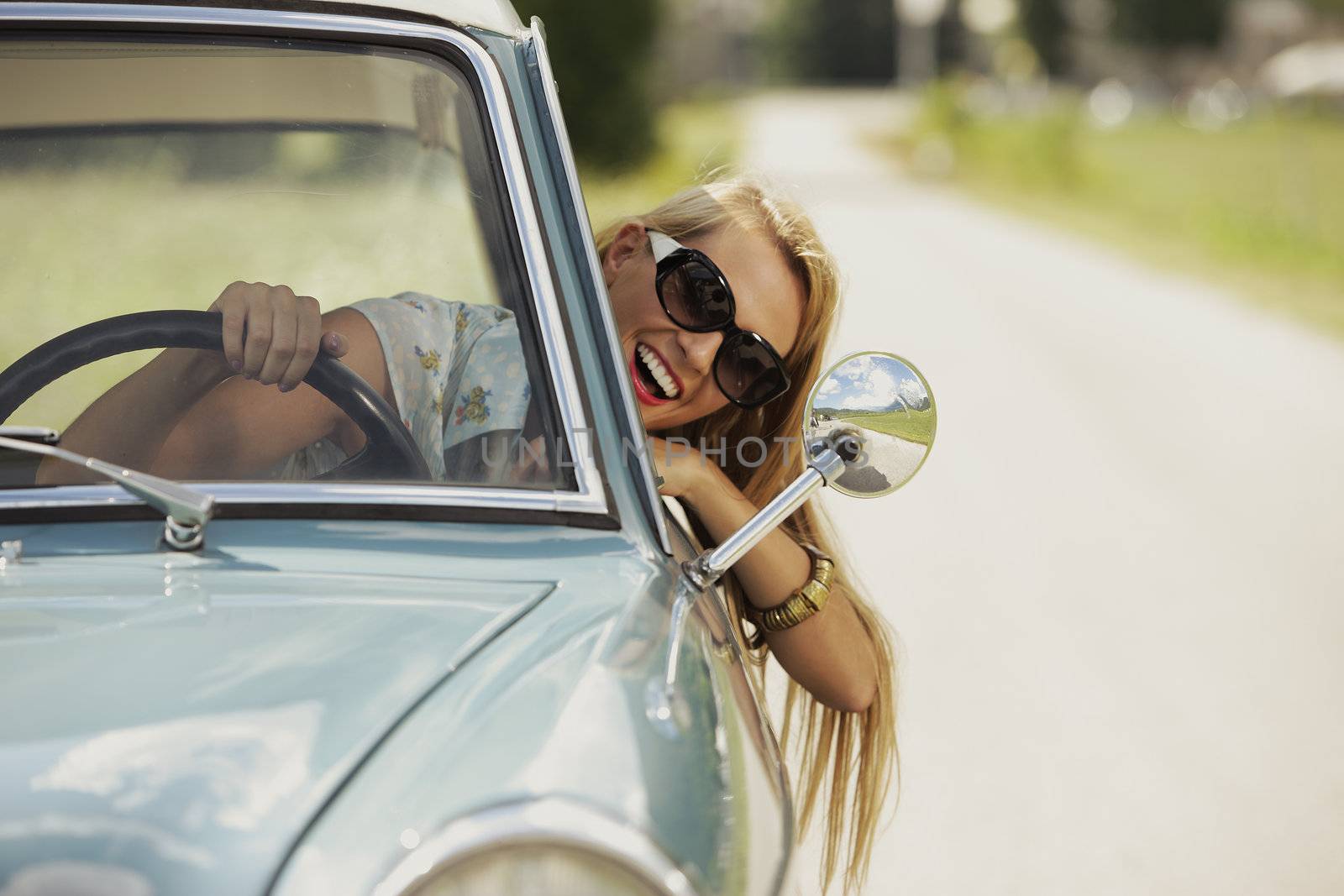 Smiling woman driving vintage car.