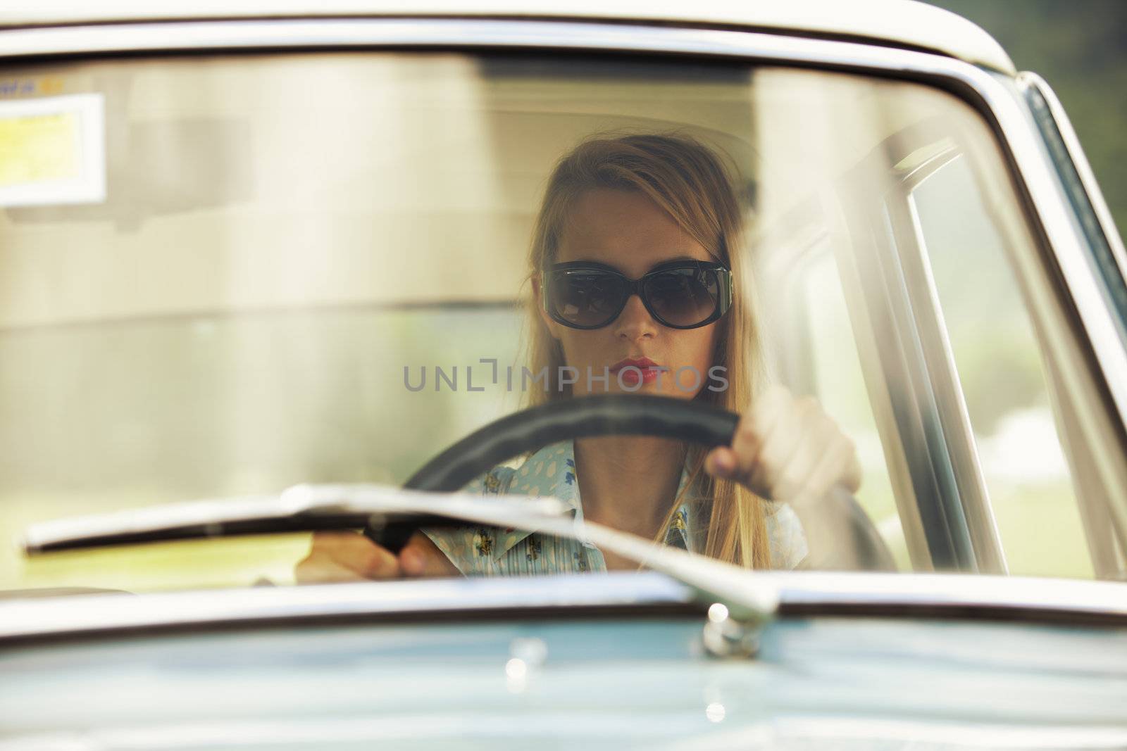 Young woman driving vintage car.