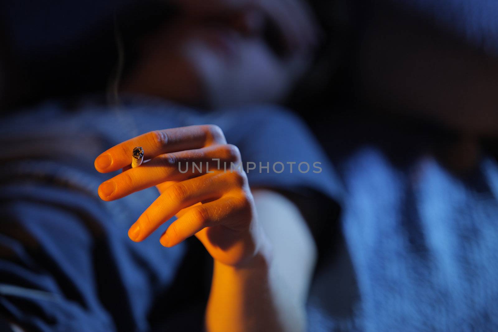 Close up of teenage boy smoking drugs lying on the couch, copy space