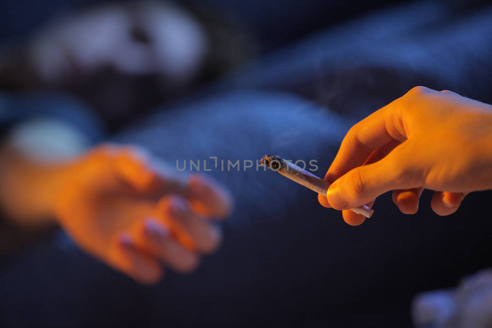 Close up of two young adults smoking a joint