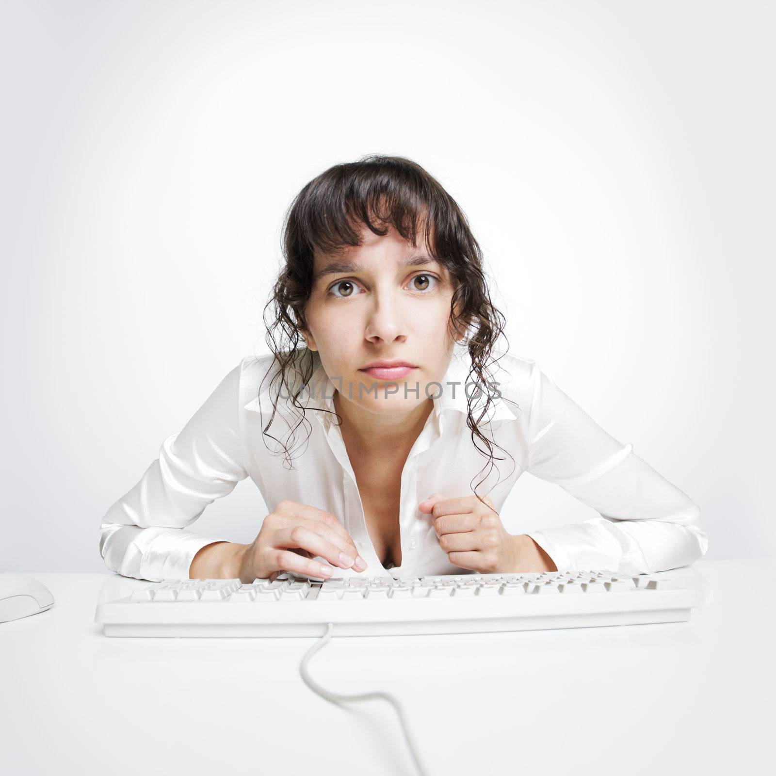 Serious frontal portrait of a woman at her office desk 