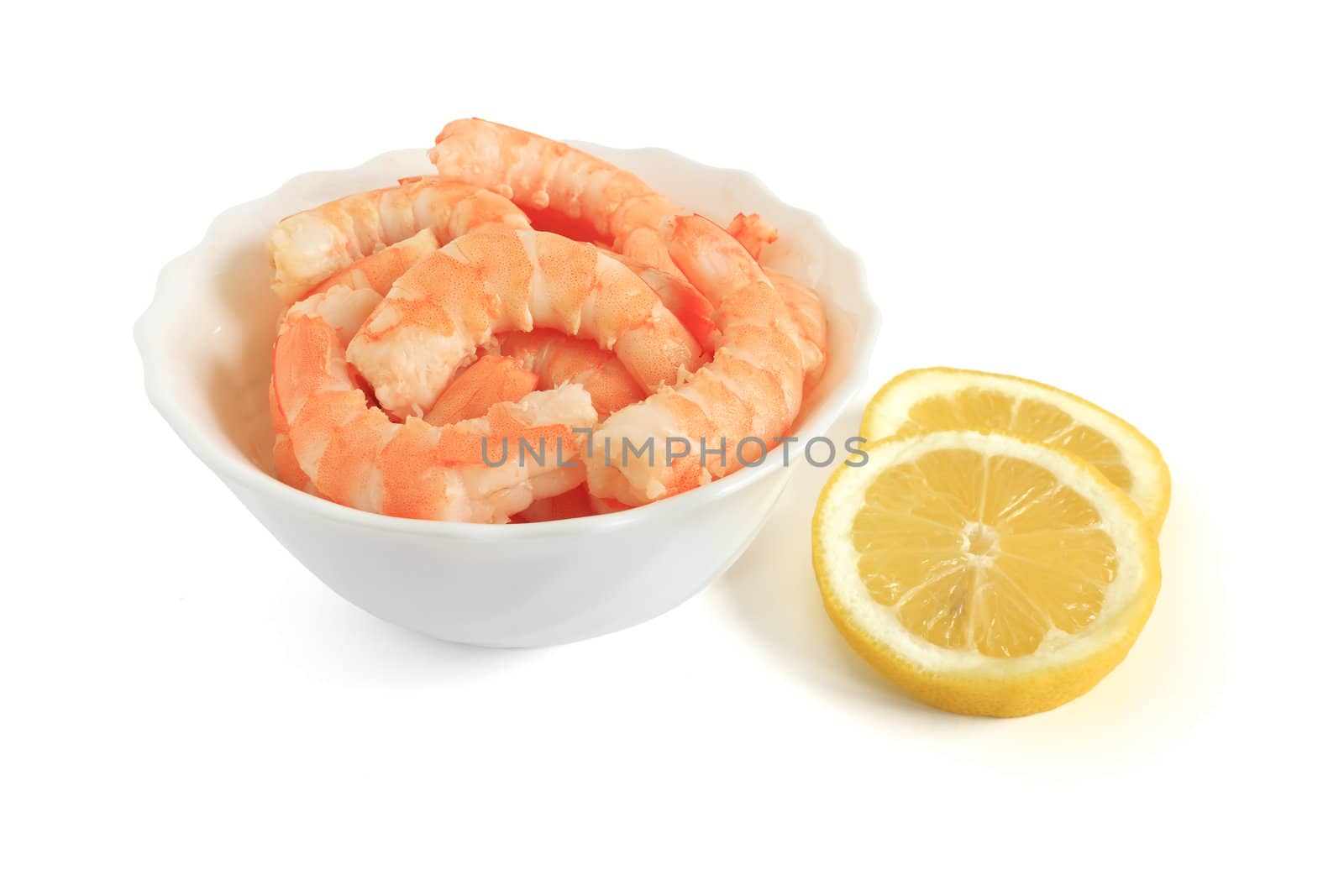 shrimps with sliced lemon in a bowl over white background