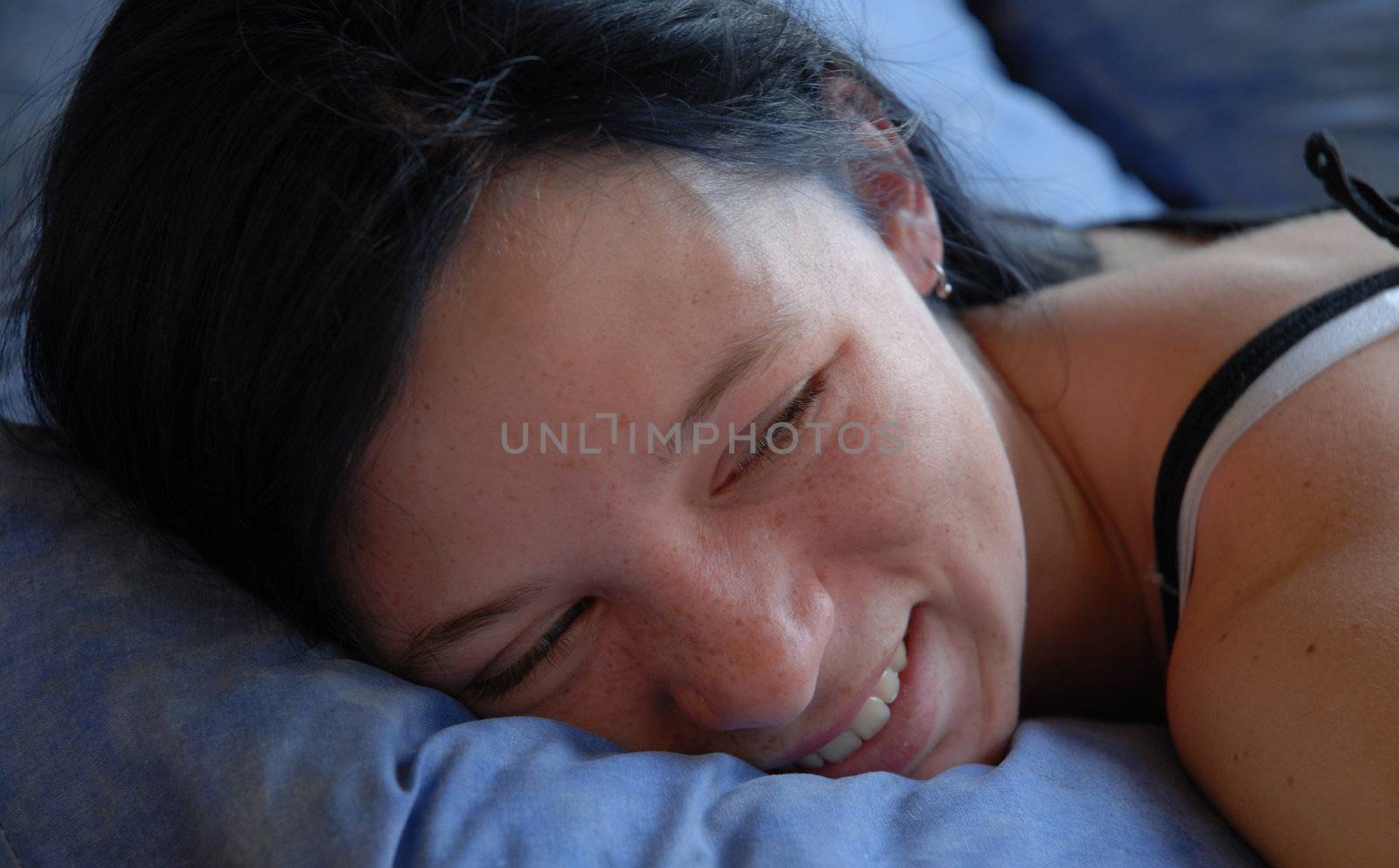 young tired teenager laid down on a blue bed