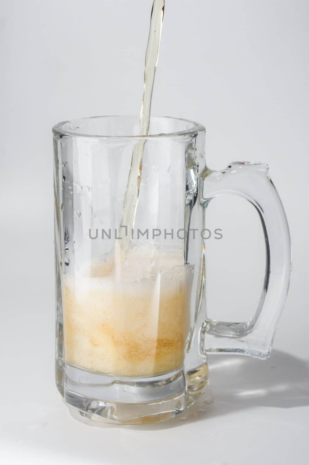 Mug, full of cold lager beer. Isolated.