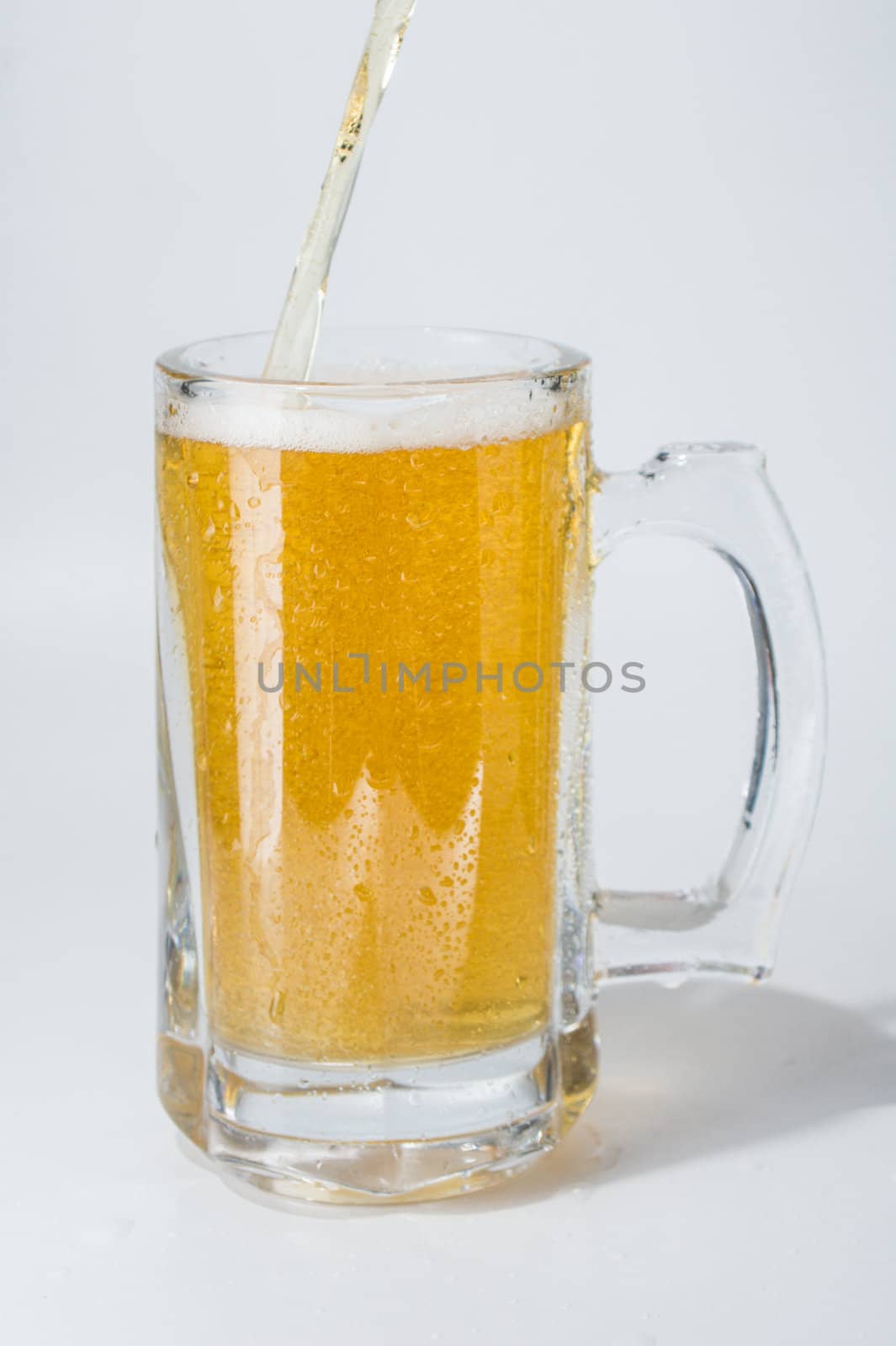 Mug, full of cold lager beer. Isolated.