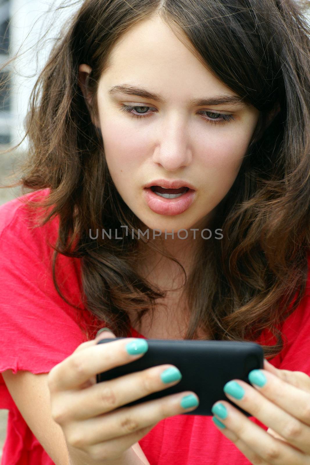 Girl in disbelief over mobile or cell phone text by Mirage3