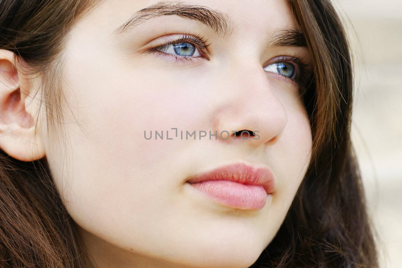 Portrait of s beautiful hopeful or pensive young woman with fair skin and light blue and green eyes, simple and natural.