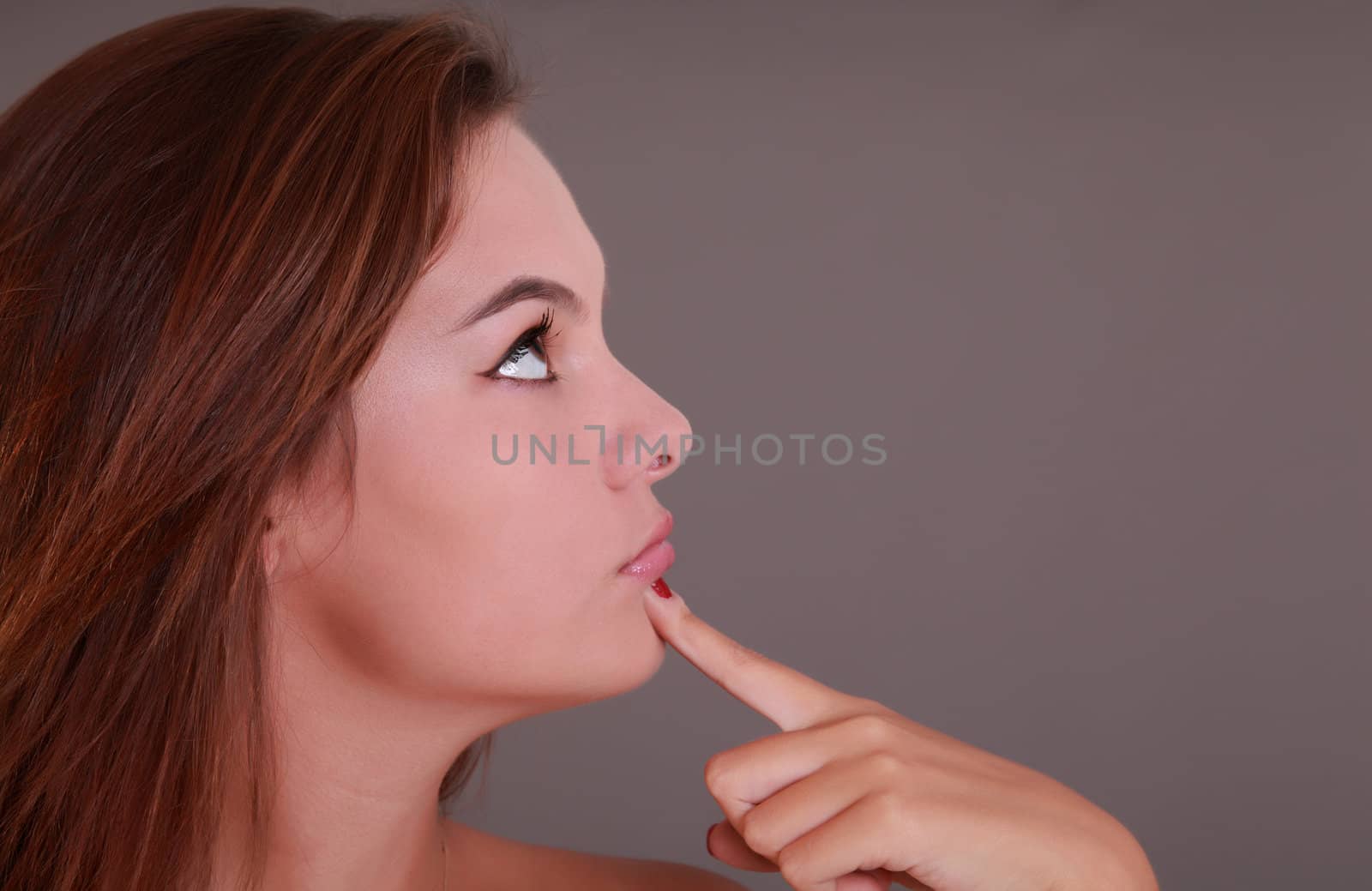 Nice girl looking on the right and finger on the chin