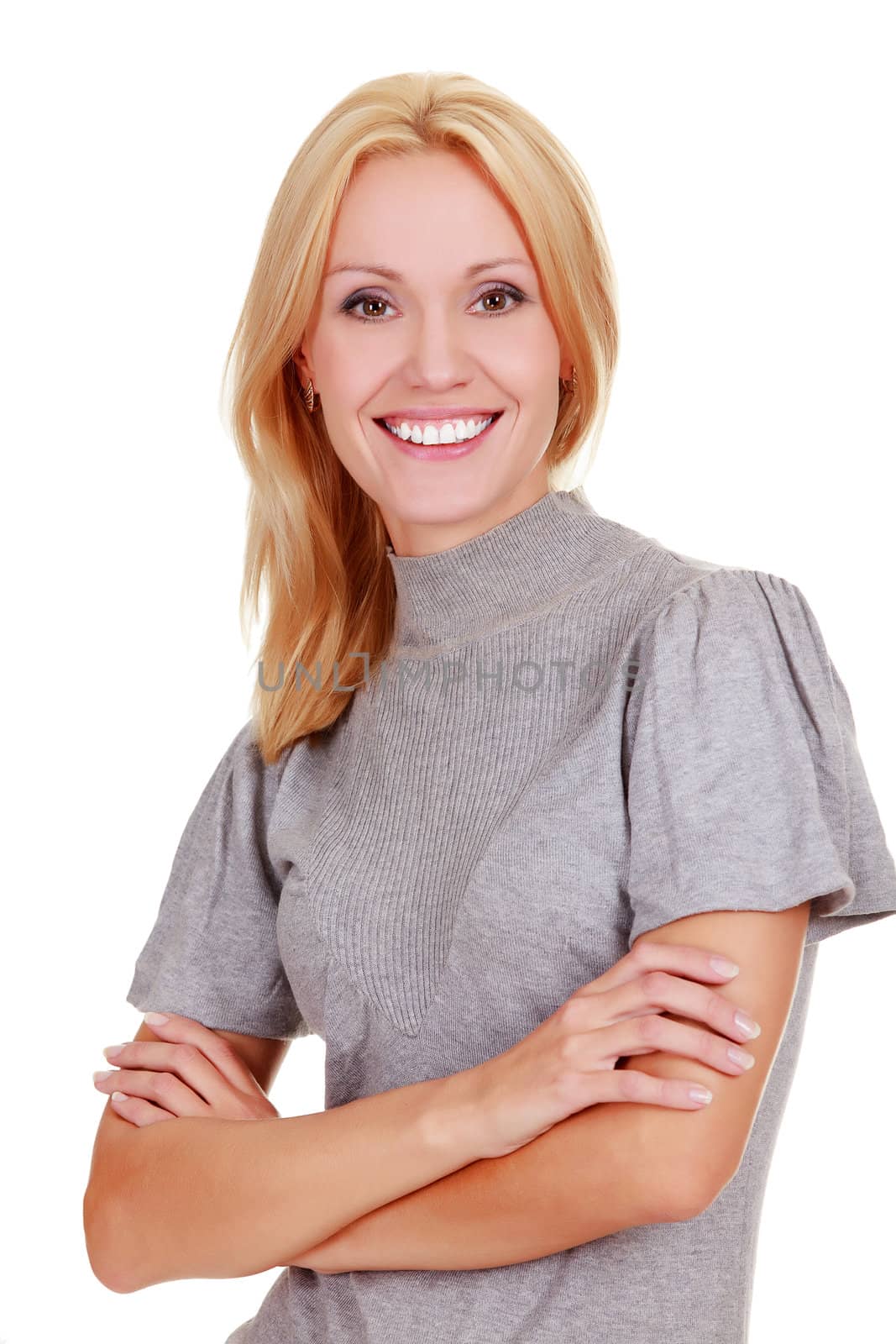 Smiling woman standing with arms folded against a white background