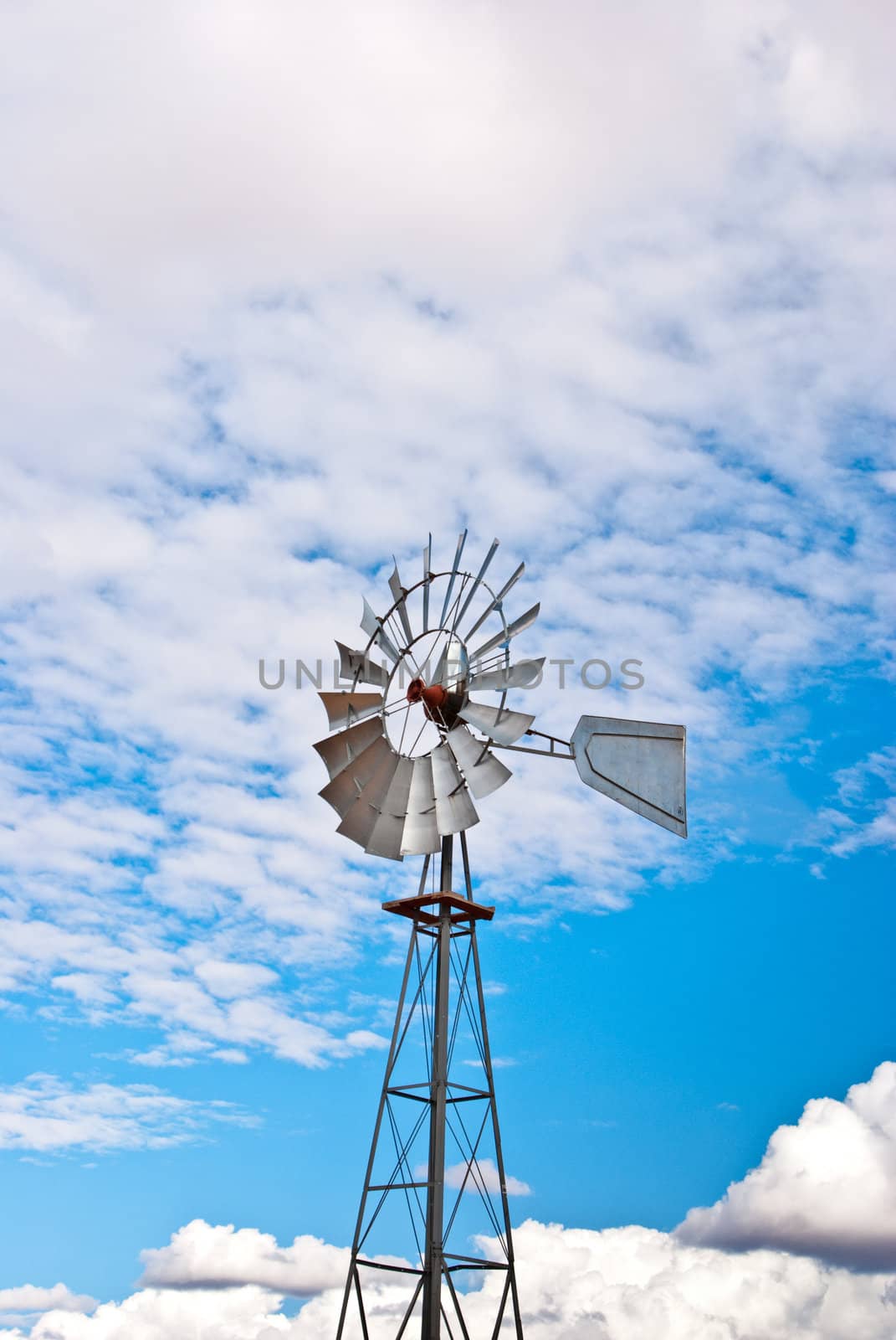 Metal windmill in desert pumps water