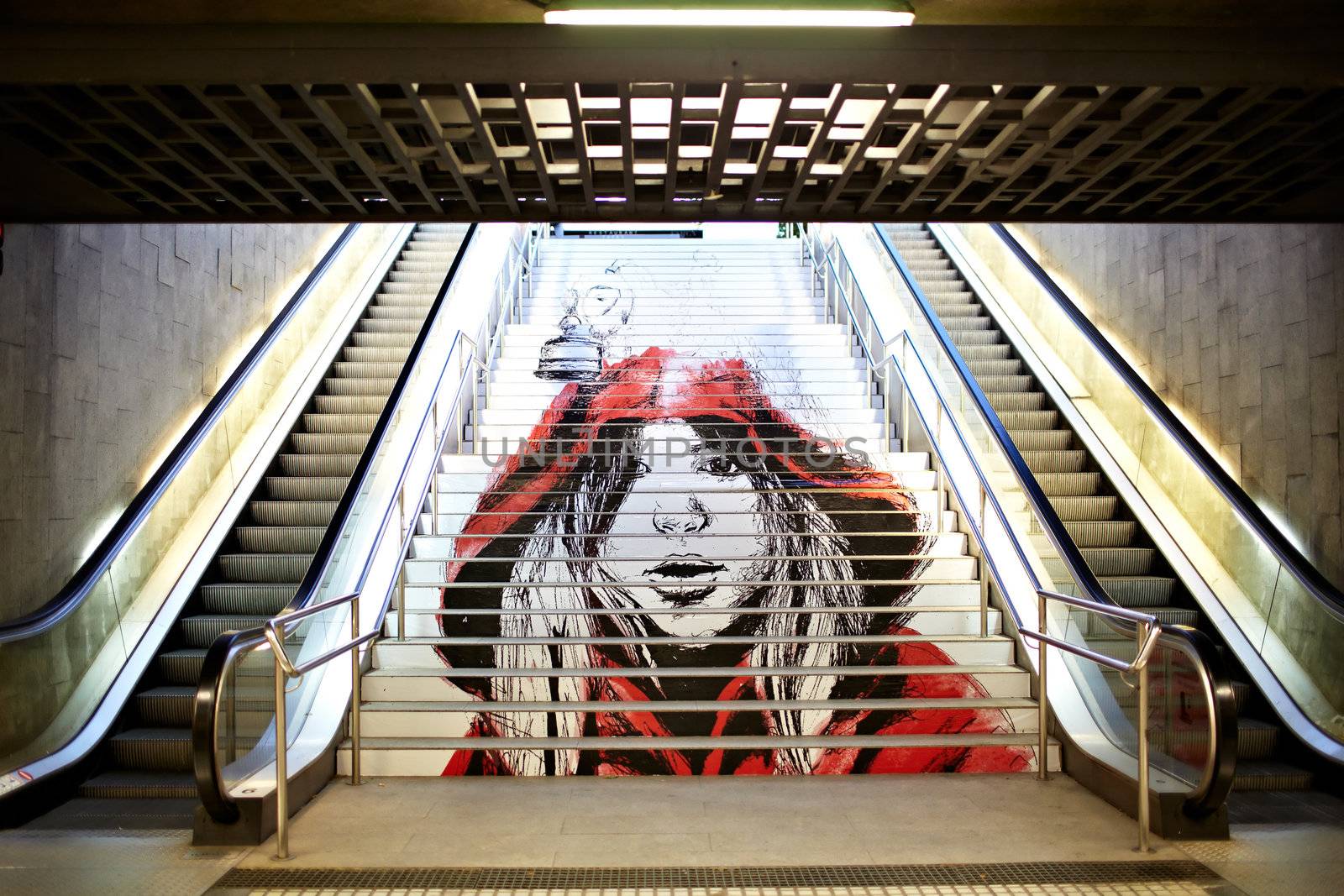 BARCELONA - MAY 23: Graffiti with the picture of a modern girl-teenager in a red loose overall on the steps of the Metro on May, 23, 2012 in Barcelona, Spain.