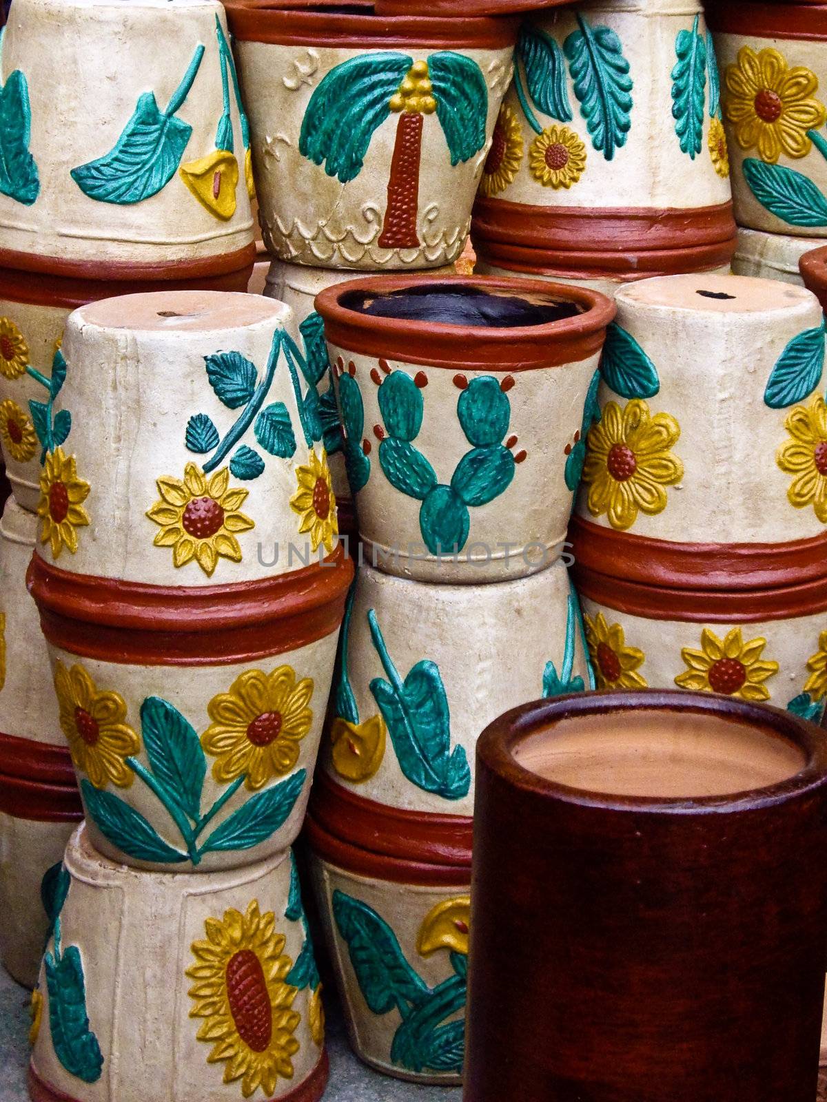 Colorful flowerpots stacked in Mexican marketplace