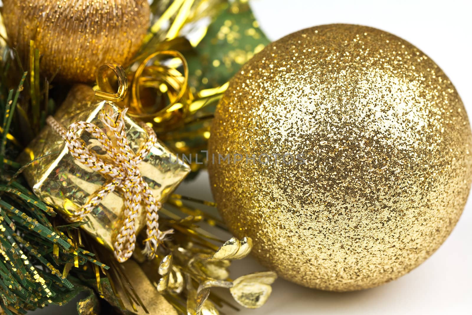 A golden christmas decoration with a sparkling bauble