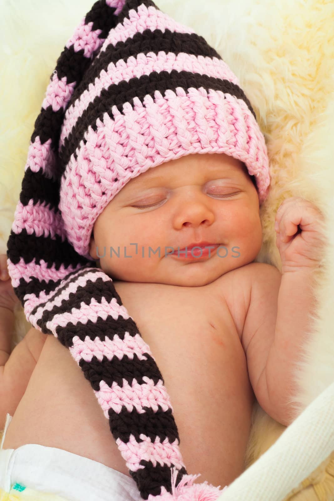 infant sleeping on a white sheepskin in a wicker basket. by sk11303