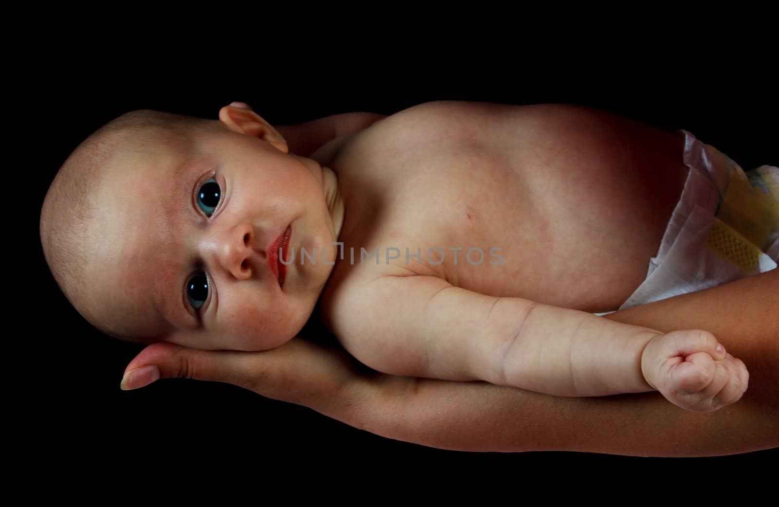 infant on the hands, on a black background. by sk11303