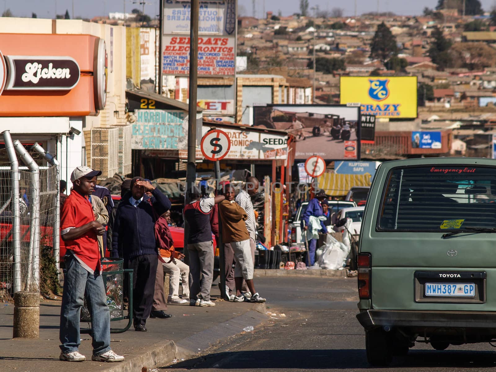 Soweto street scene, showing people and the housing background.