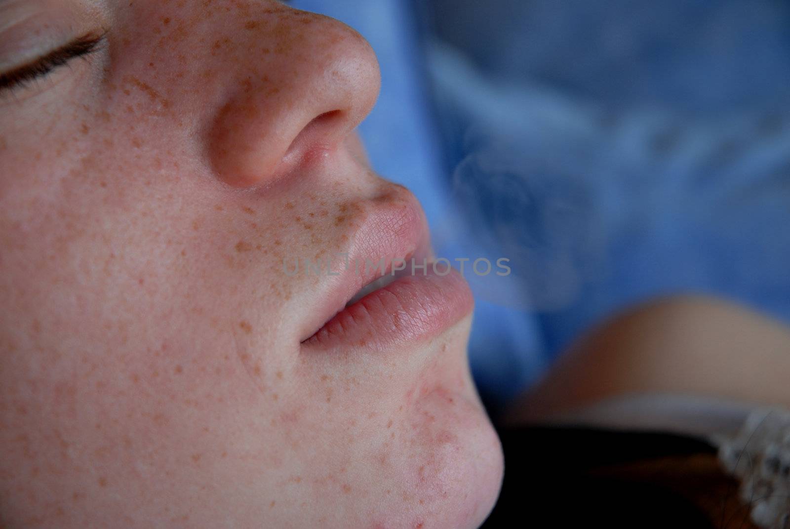 a young teenager making a smoke with her mouth