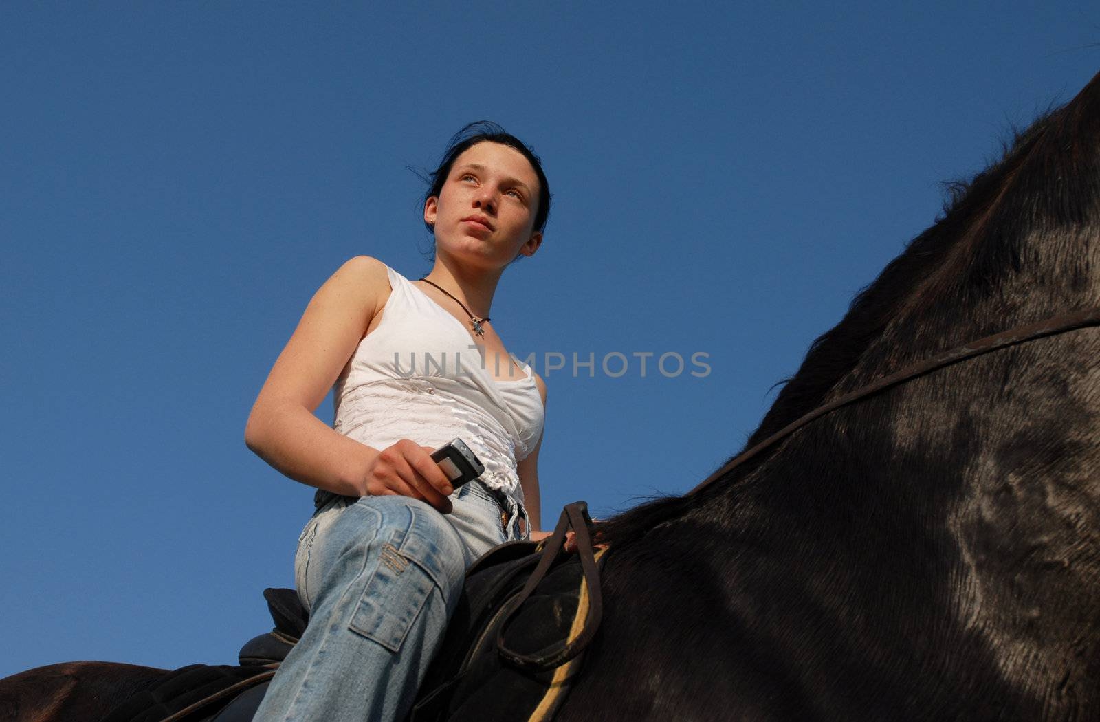 young woman and her black stallion in a field