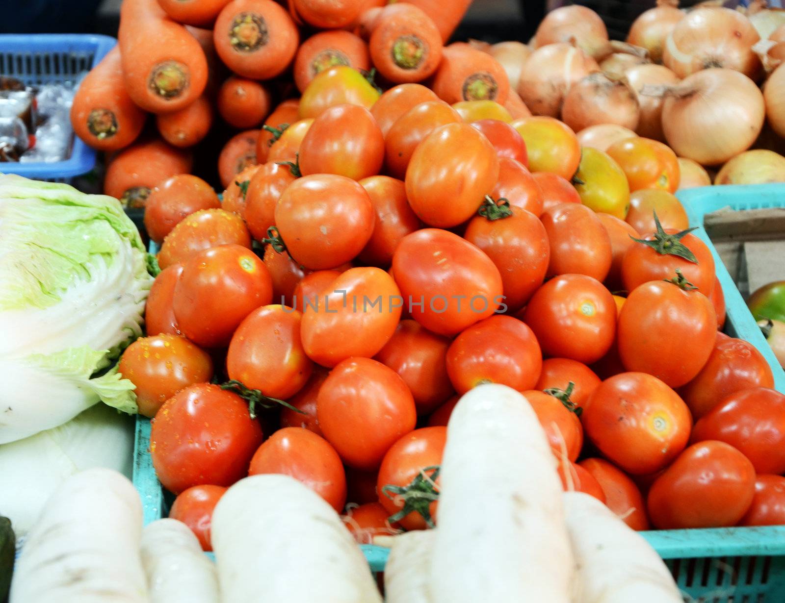 Baskets of tomatoes and vegetable for sale at a farmer's market. 