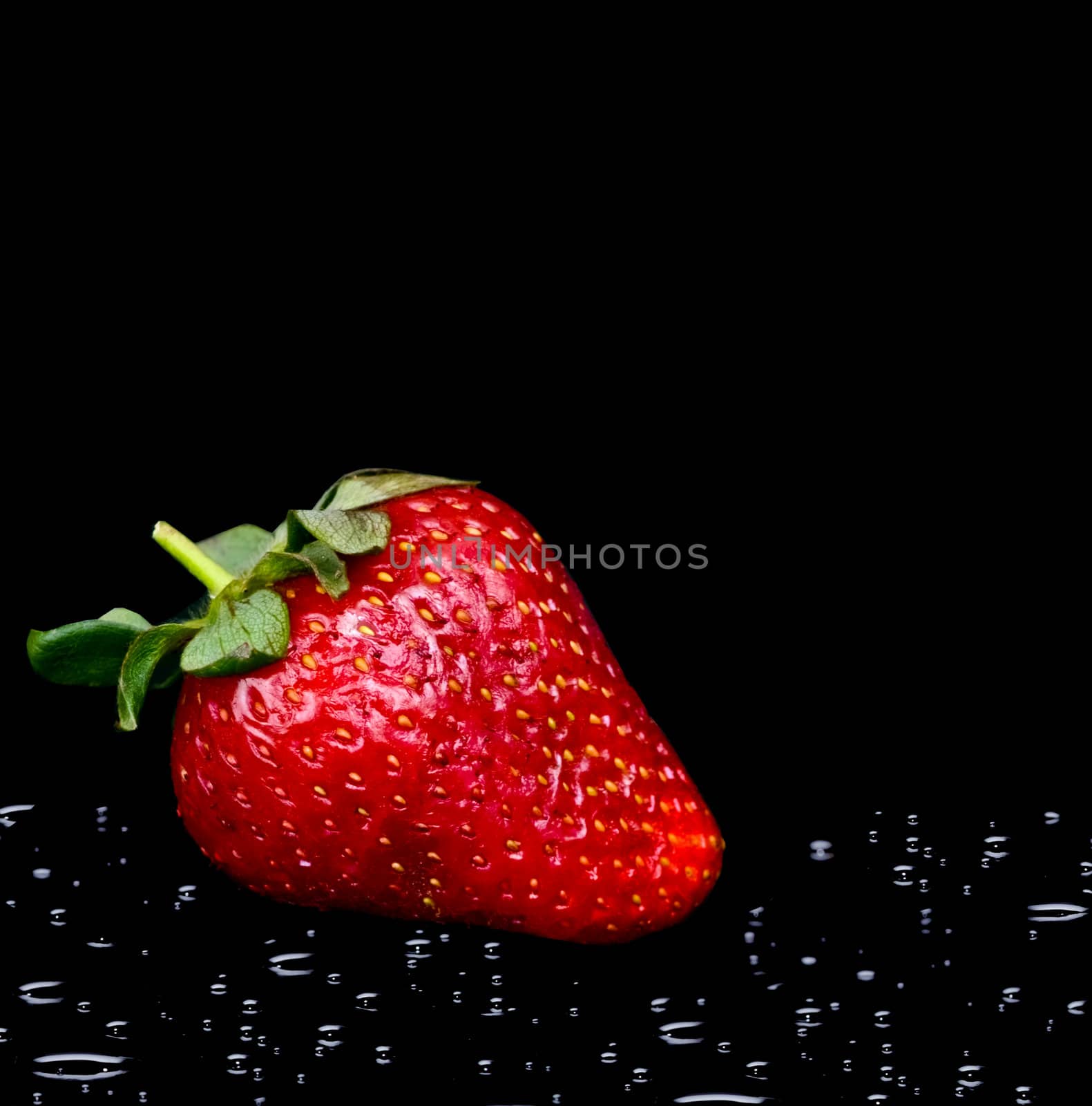 fresh strawberry with water drops on black background
