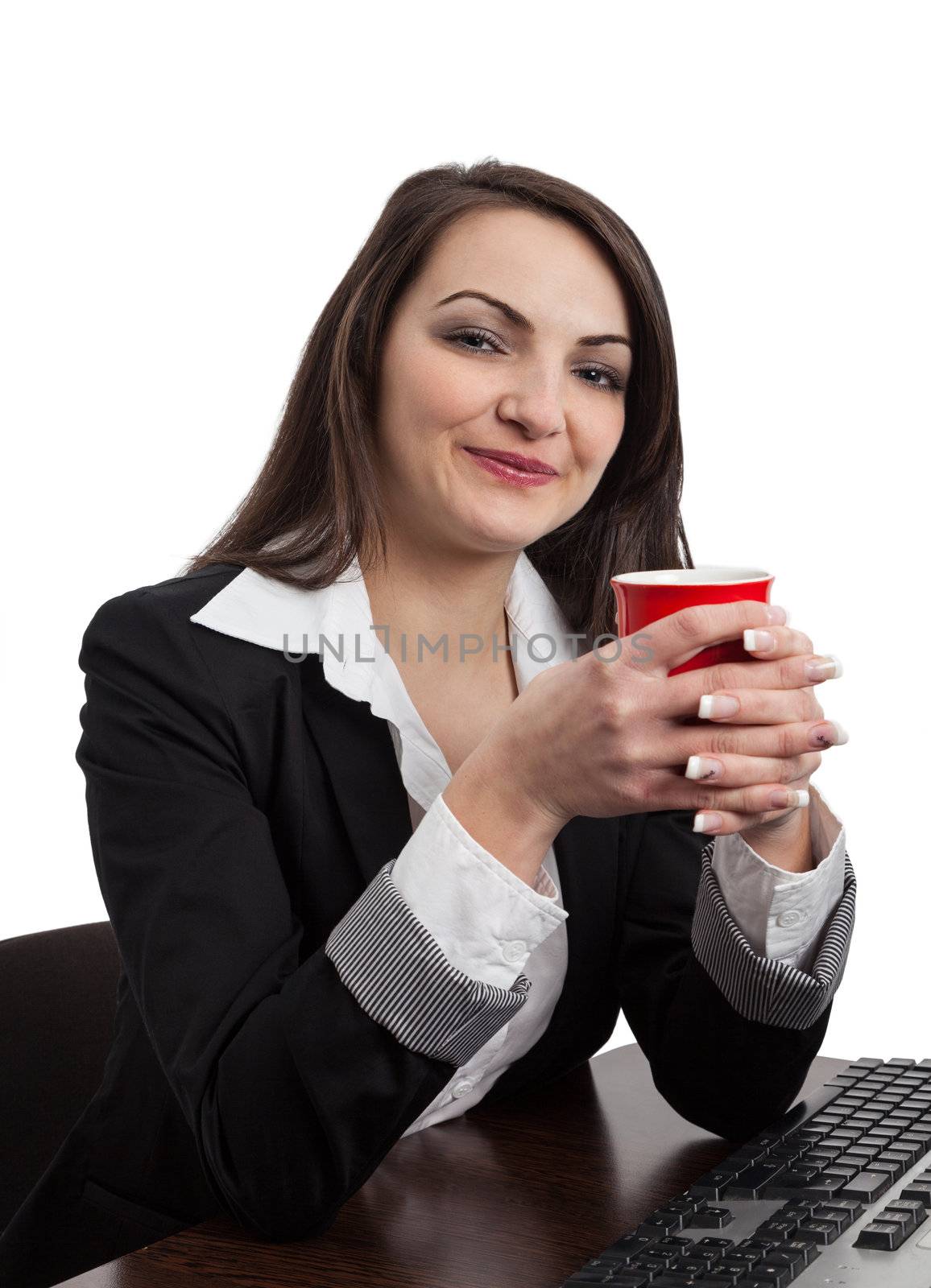 Portrait of a smilling young woman holding a red cup in her hands at the office, isolated against a white background.