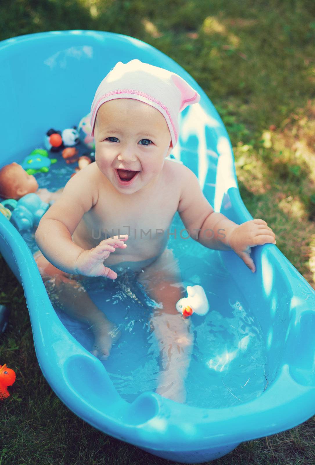charming baby having bath in blue tub