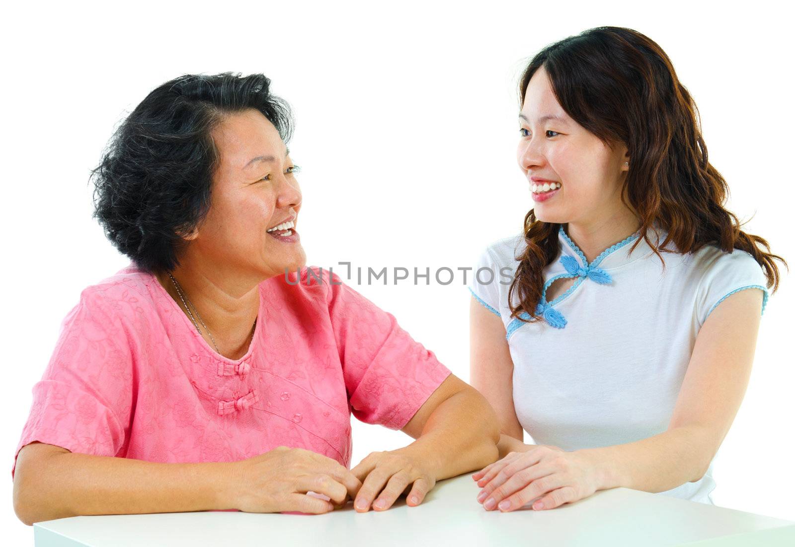 Adult daughter having conversation with senior mother indoor.