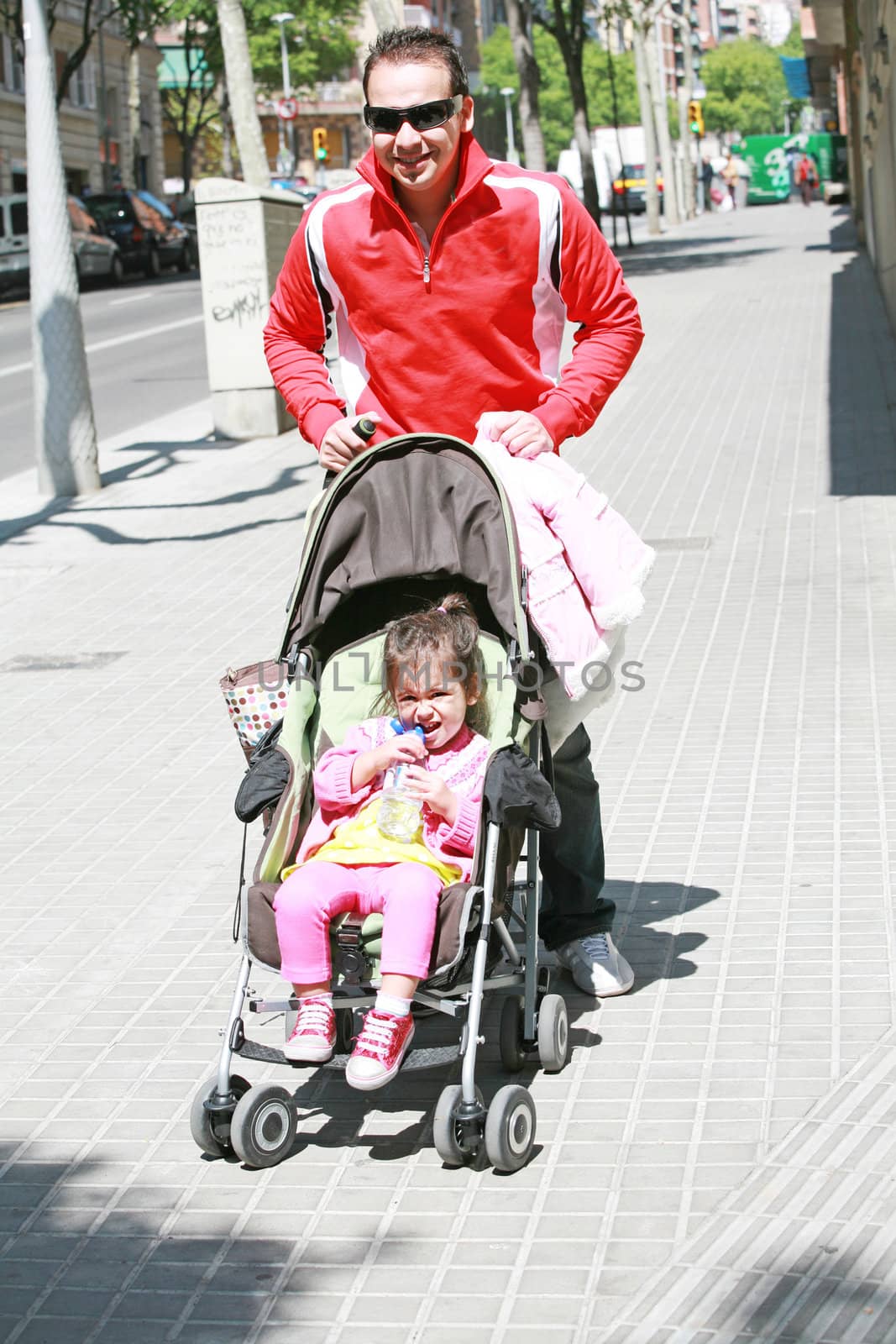 Happy father smiling with his daughter in baby carriage