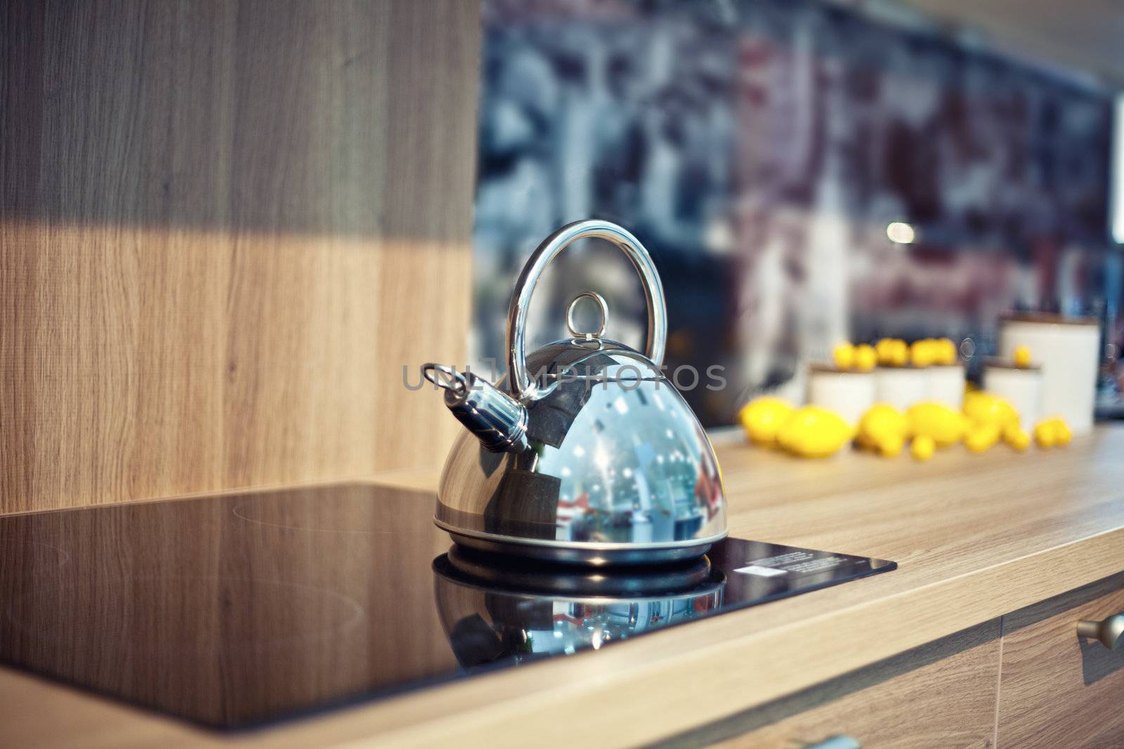 Shiny tea kettle on the kitchen table (beautiful diepth of field effect)