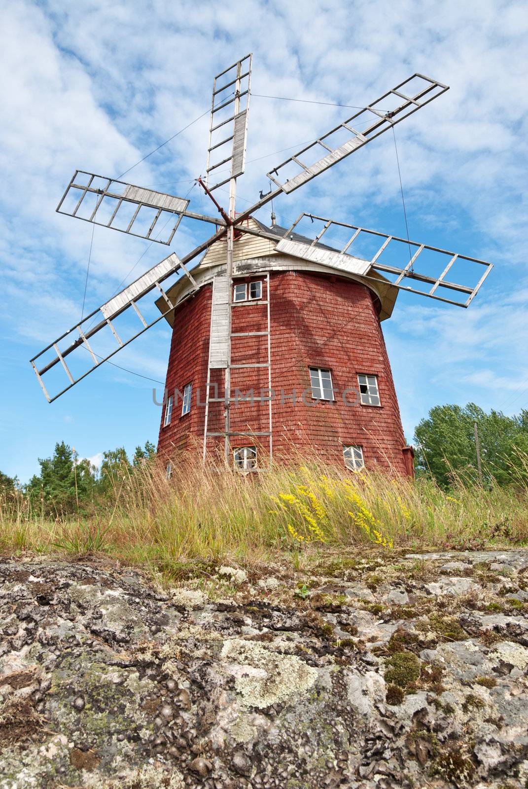 Old wooden windmill in Sweden, painted in traditional red color.