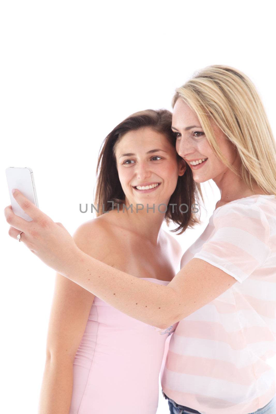 Two attractive young women standing close together in front of their mobile phone posing for a photograph 